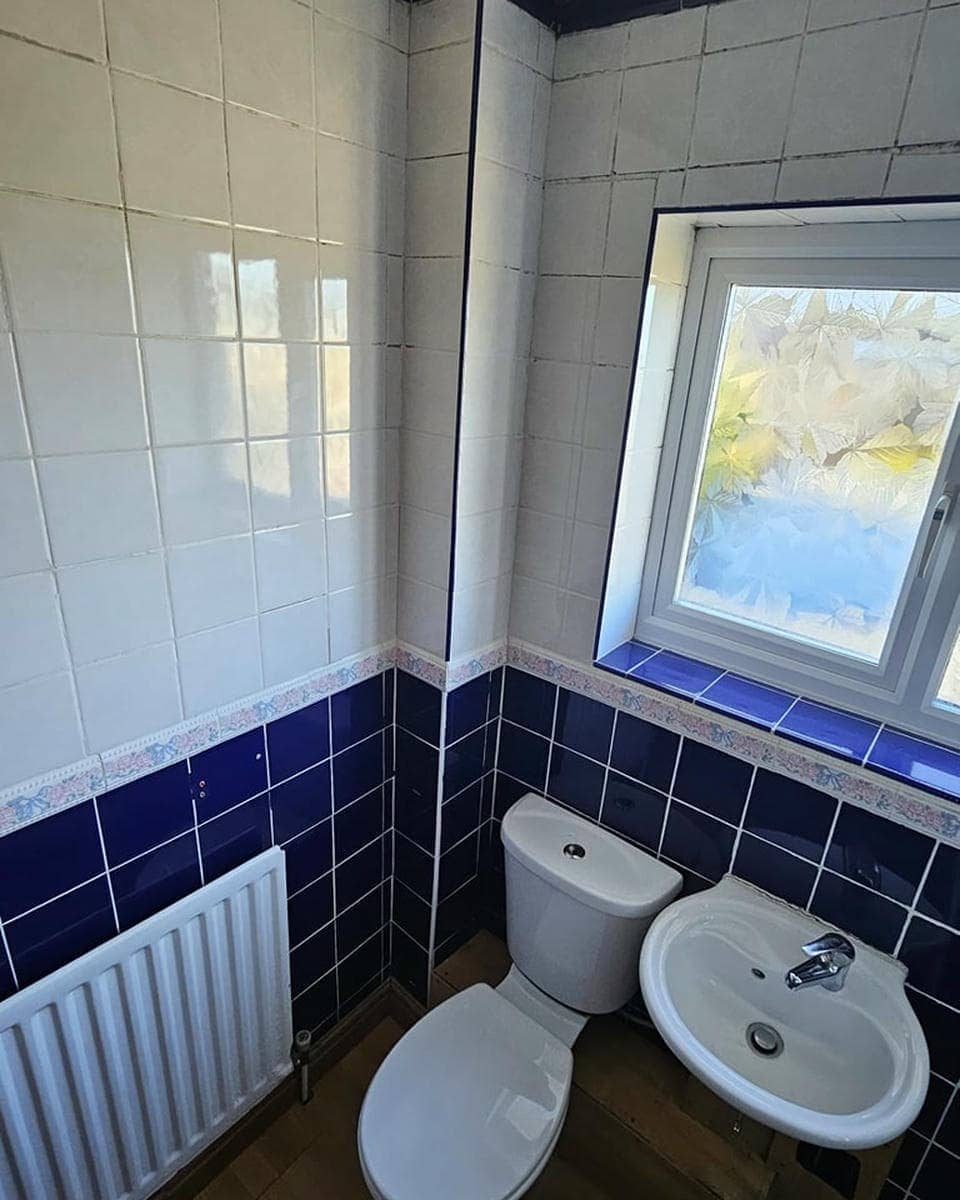 Mavi beyaz seramikli banyo ve pencere