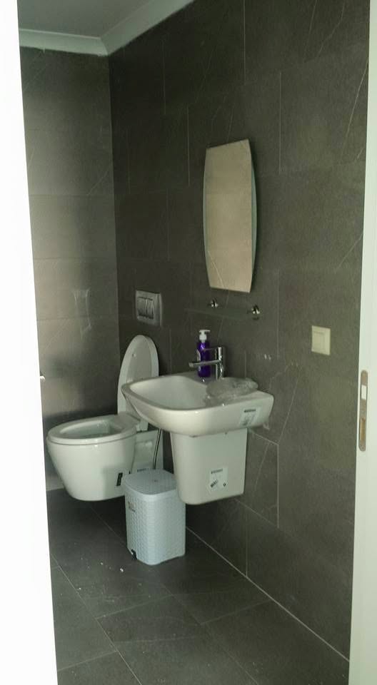 Duvar tipi lavabo ve koyu renk banyo fayansları