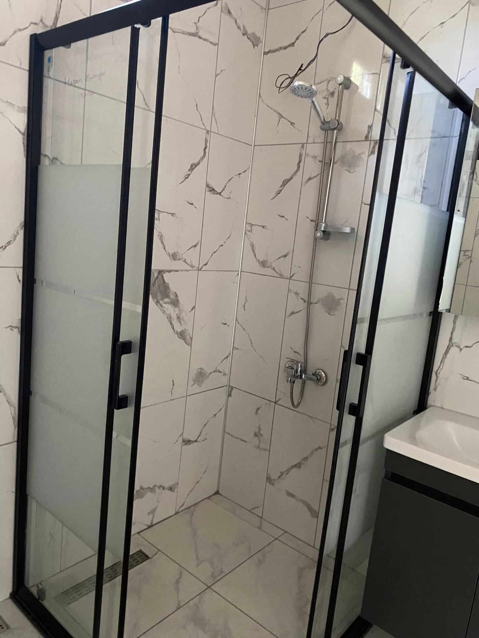 Mermer desenli fayans ve cam duş kabinli banyo